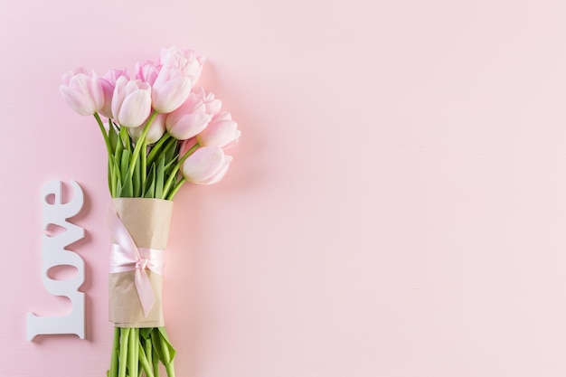 Bouquet of pink tulips on a pink background.