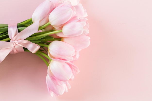 Bouquet of pink tulips on a pink background.