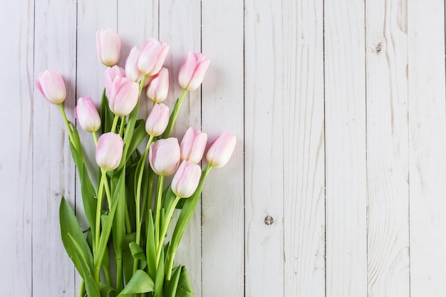 Bouquet of pink tulips on a wood background.