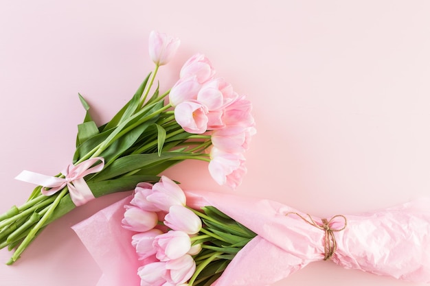 Bouquet of pink tulips wrappen in pink paper.