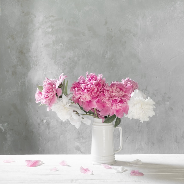 Bouquet of pink and white peonies  on background old wall