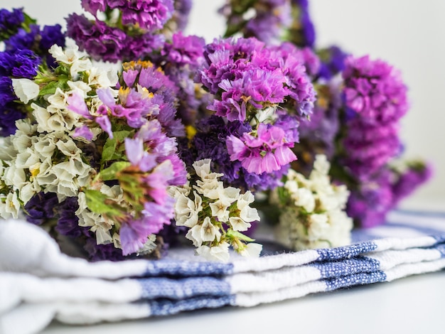 A bouquet of purple flowers is on a kitchen towel