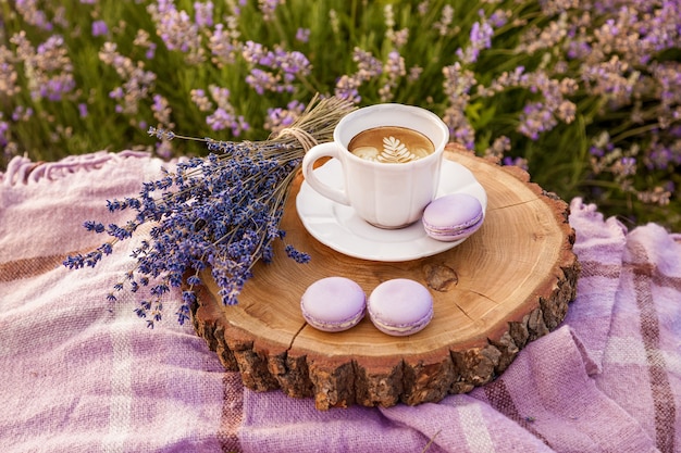 A bouquet of purple lavender a white cup with coffee biscuits and plaid on the farm