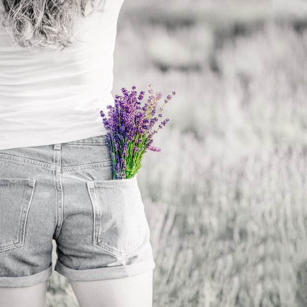 Bouquet of purple violet lavender flowers in the jeans pocket