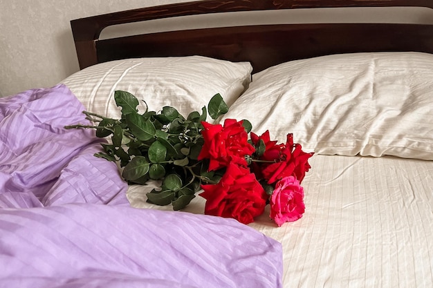 Photo a bouquet of red roses lies on the whitelilac bed linen aesthetic minimalism greeting card with good morning