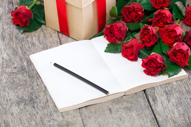 Bouquet of red roses, notebook and present