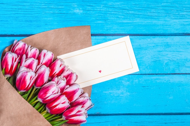 Bouquet of red tulips for the holiday women's day and valentine's day on the background of wooden boards.