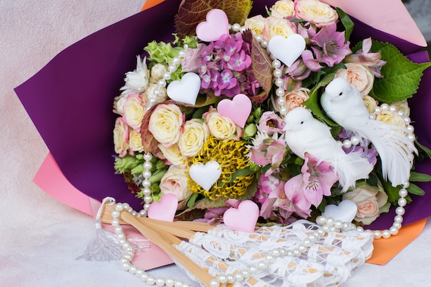 A bouquet of roses, hydrangeas and two white doves,  satin hearts, pearl beads