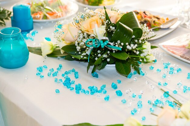 Bouquet of roses and turquoise decoration on the wedding table