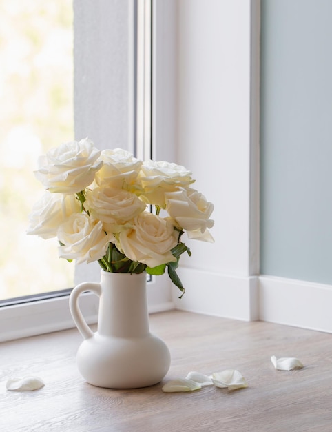 Bouquet of roses in white jug in modern interior