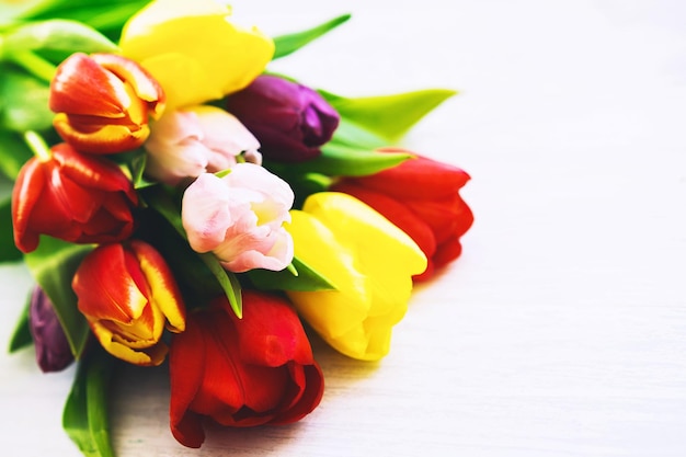 Bouquet of spring flowers Beautiful tulips on wooden white background with copy space Flat lay top view