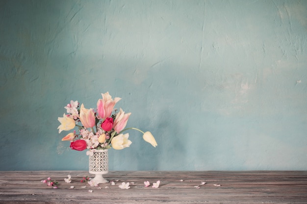 Bouquet of spring flowers on old blue wall