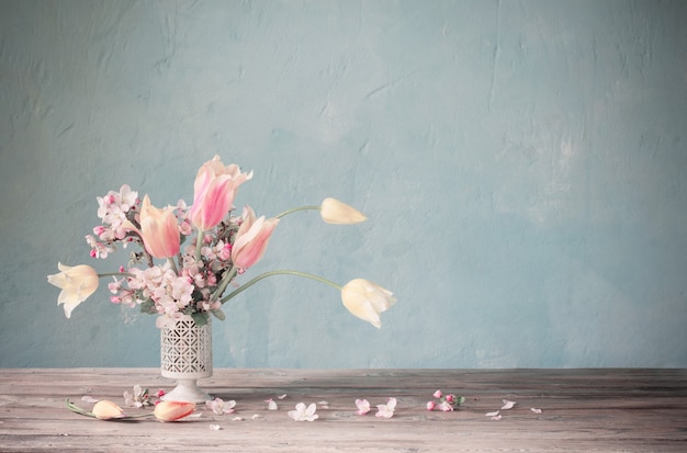 Bouquet of spring flowers on vbackground old blue wall