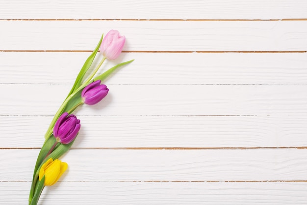 Bouquet of tulips on white wooden background