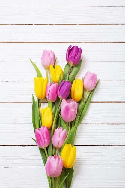 Bouquet of tulips on white wooden background