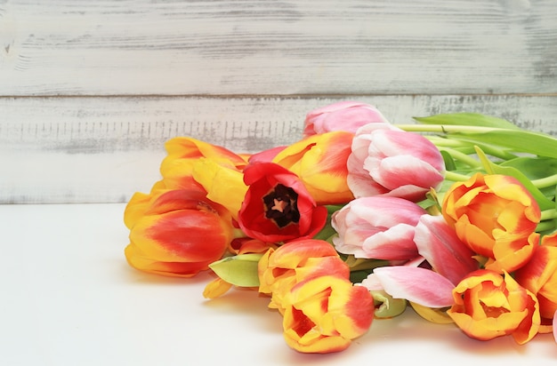 Bouquet of tulips on white wooden background. 