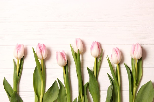 A bouquet of tulips on a wooden background top view spring background