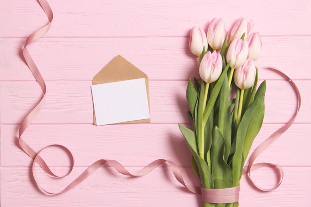 A bouquet of tulips on a wooden background top view spring background