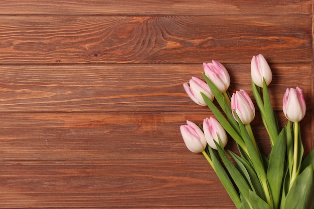 A bouquet of tulips on a wooden background top view spring background