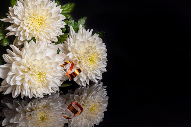 Bouquet of white chrysanthemum on a dark background with reflection Holiday gift