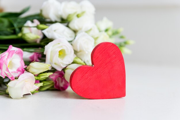 A bouquet of White eustoma flower with a heart on white