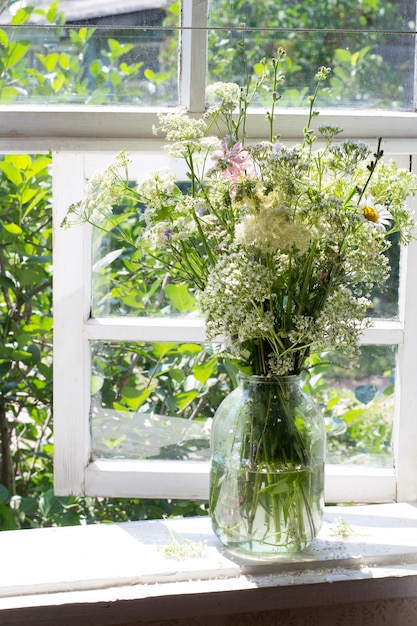 Bouquet of wild flowers on windowsill