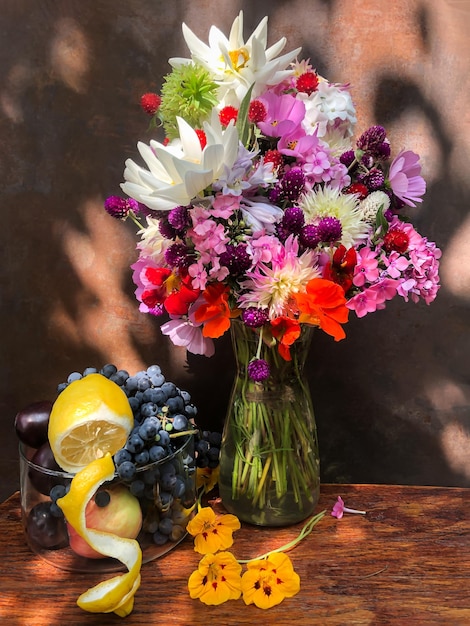 Bouquet with dahlias phlox nasturtium gomphrena eucomis grapes and lemon