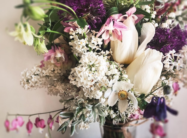 Bouquet with lilac tulips tarantula daffodils dicentra aquilegia