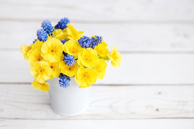 Bouquet of yellow and blue flowers on a white table