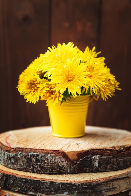 Bouquet of yellow dandelions in a bucket