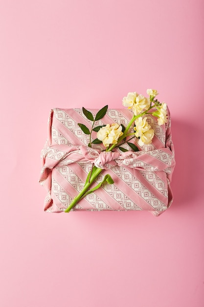 Photo bouquet of yellow matthiola with gift wrap in traditional japanese furoshiki style design concept of...