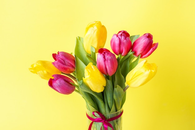 Bouquet of yellow and pink tulips on yellow 