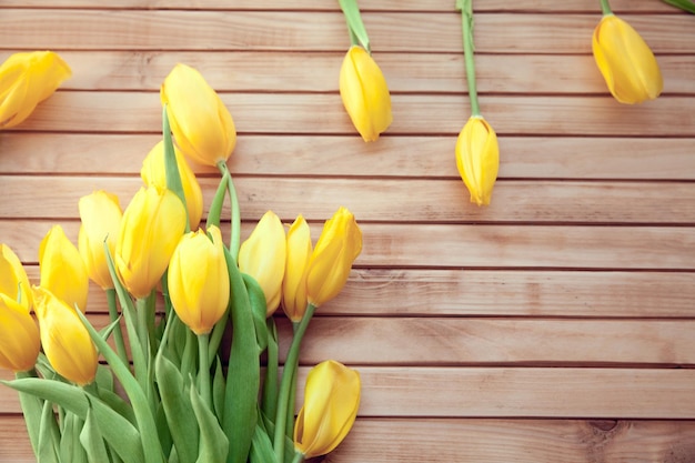 Bouquet of yellow tulips on wooden background