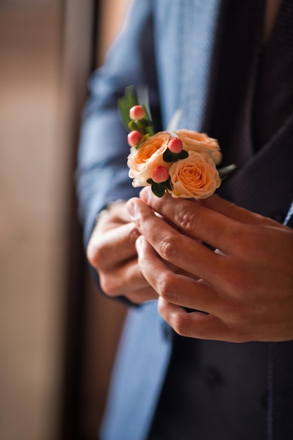 A boutonniere in mens hands before the wedding 4255