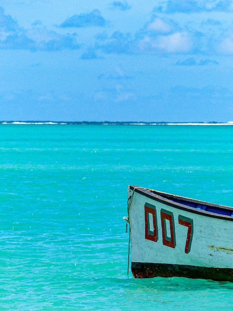 Bow of a boat with the inscription 007 in crystalclear turquoise water on Mauritius