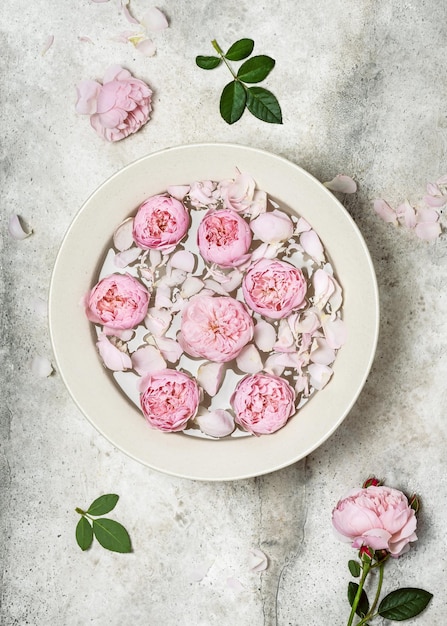 Bowl of aroma spa water with pink rose petals and flowers Relaxation and harmony concept