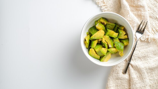 A Bowl of avocado slices isolated on white background