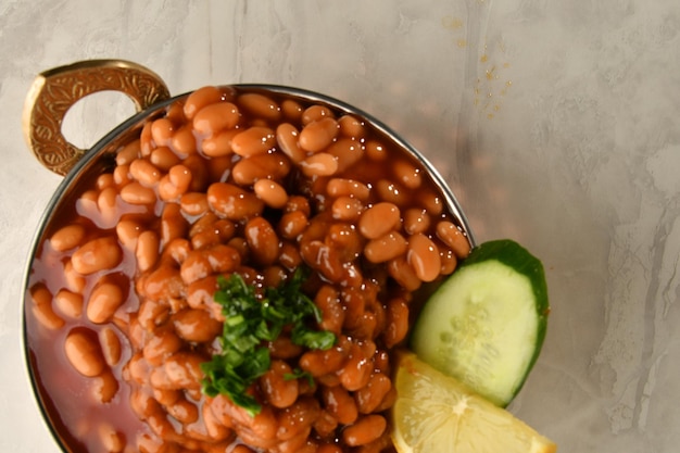 Photo a bowl of baked beans with a lemon wedge