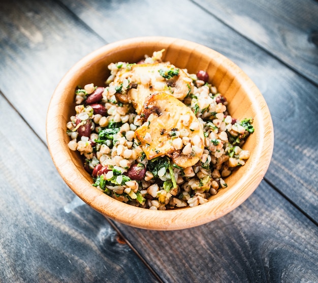 bowl of boiled buckwheat with fried champignon, spinach and red beans