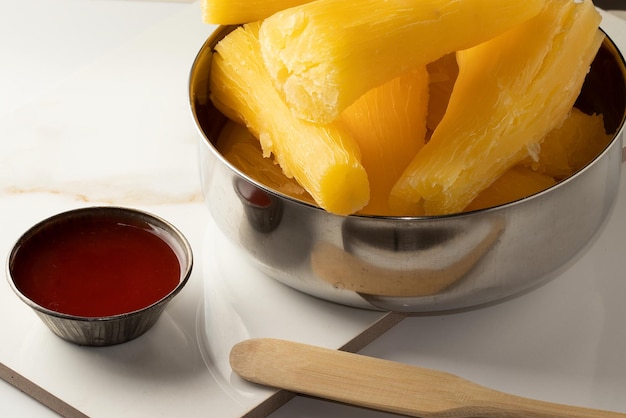 A bowl of boiled manioc served with chilli sauce