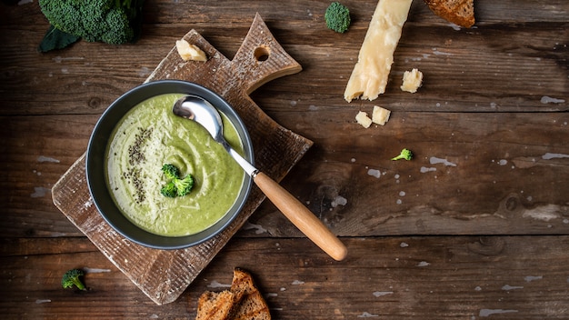 Bowl of broccoli cream soup with parmesan cheese and crunchy croutons