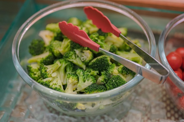 A bowl of broccoli with a red handle and a red handle.