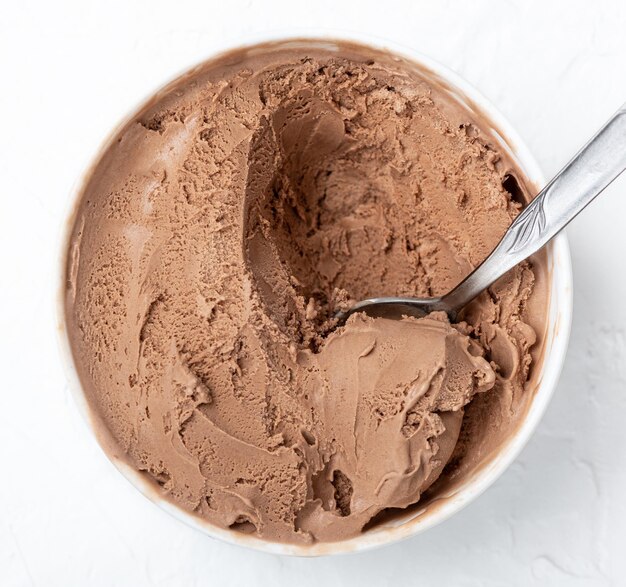 Bowl of chocolate ice cream on white wooden background From top view