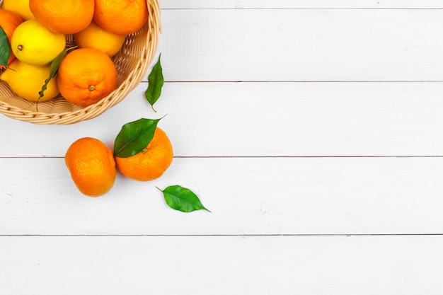 Bowl of citrus fruits on white wooden background