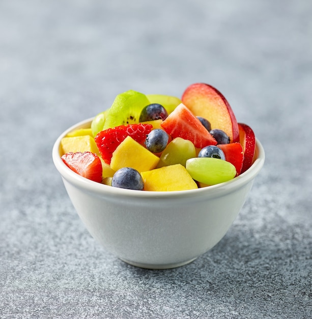 Bowl of colorful fresh fruit salad on kitchen table