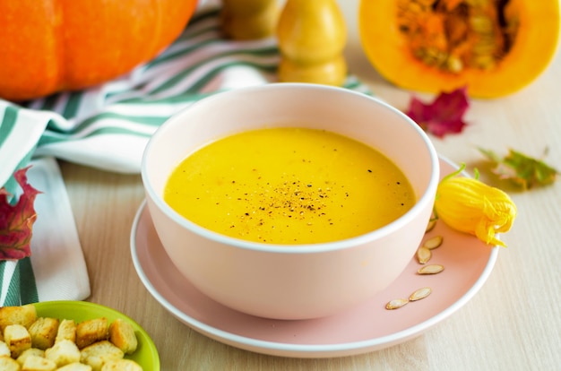 Bowl creamy pumpkin soup with vegetables, seeds and croutons, olive oil. Thanksgiving Day. traditional autumn dish.