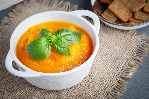 Bowl of delicious autumn pumpkin soup with rye croutons