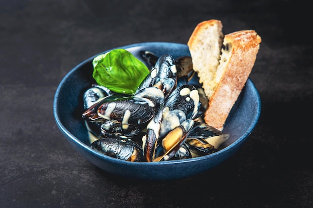 A bowl of delicious steamed mussels with grilled bread