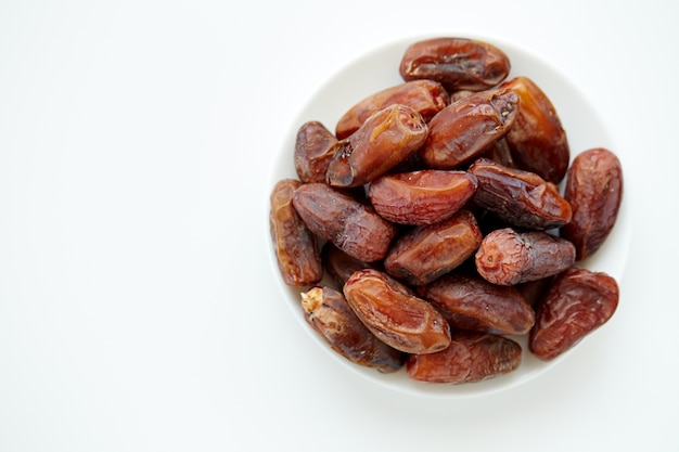 Bowl of dried dates isolated on white backgroun