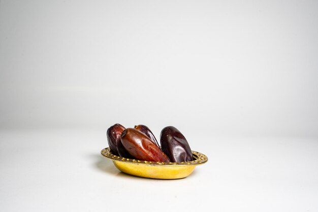 A bowl of dried dates isolated on a white background. Ramadan Kareem, dates